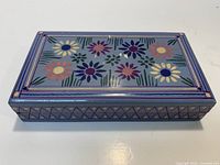 Closed box showing floral painted lid