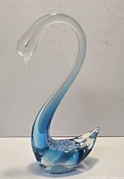 Front view of clear and blue hand blown glass swan, approx 11.5 in tall