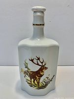 Front view showing stag design on white porcelain decanter with stopper