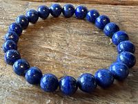 Full view of lapis lazuli bead bracelet on wood surface
