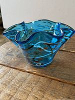 Angled view of aqua blue ruffled glass bowl