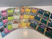Spread of Pokémon cards in individual top loader sleeves