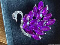 Front view of brooch highlighting purple marquise stones and clear rhinestone neck
