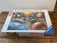 Front and side views of sealed Ravensburger 1000-piece space planets puzzle box