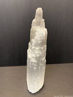 Full view of the white translucent selenite tower wand showing stepped formation and vertical striations