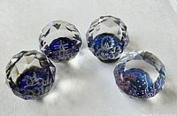 All four faceted crystal paperweights showing cobalt blue centers and etched designs (ship, Ferris wheel, Australia map with flag, anchor)