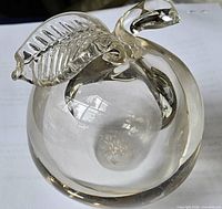 Full view of clear glass apple with leaf and stem