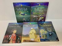 Front view of five sealed Studio Ghibli Disney DVDs