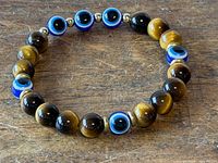 Full view of stretch bracelet showing tiger's eye beads, evil eye beads, gold spacers
