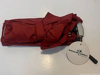 Umbrella folded with sleeve and hang tag visible