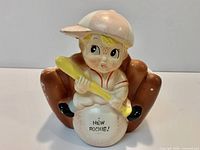 Front view of ceramic napkin holder with child baseball player and glove