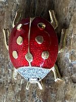 Top view showing red enamel wings, gold spots, and crystal head