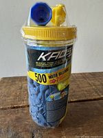 Front view of sealed KAOS jar showing label and blue balloons