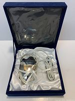 Mouse and cable seated in satin-lined presentation box