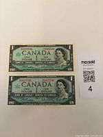 Fronts of both 1967 Canadian $1 notes showing Queen Elizabeth II portrait and serial numbers