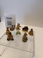 Front view showing all eight small Wade figurines on acrylic riser