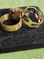 Three gold-tone rings grouped to show designs