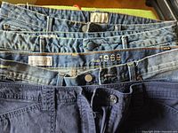 Four waistbands stacked showing different brands and waist details