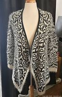 Full view of black and white open-front cardigan on mannequin