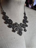 Full view of necklace on mannequin, showing overall design and drop