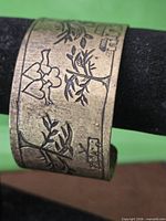 Overall view of cuff showing engraved hearts and tree branches