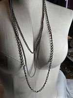 Full view of layered dark silver-tone necklace on mannequin
