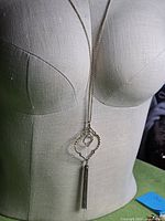 Full view of necklace on mannequin showing chain length, rhombus pendants and tassel