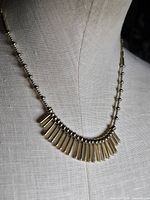 full view of necklace on bust showing bar fringe and beaded chain