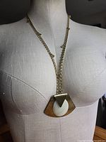 Necklace displayed on dress form to show pendant size and chain length