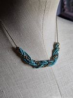 Necklace on form showing braided bead section and chain