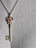 Necklace displayed on fabric bust showing full skeleton key pendant with rose detail