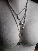 Necklace displayed on dress form showing layered arrangement and pendant positions