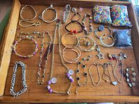 Overhead view of entire lot displaying all jewellery pieces and bead packs on wooden tray