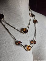 Necklace shown doubled on form displaying stones and chain