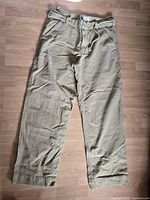 Full view khaki pants laid flat showing overall condition and style