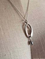 Necklace close-up showing oval pendant and bead