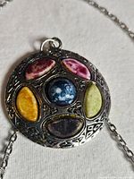 Close-up of pendant showing stone arrangement and metal detailing