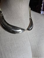 Necklace on bust showing crescent plates and chain attachment