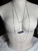 Front view of double-strand necklace on mannequin showing silver bar accent and lapis bar pendant