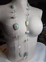 Full view of necklace draped on mannequin showing bead arrangement and chain