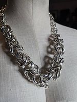 Front view of chunky silvertone interlocking link necklace on mannequin