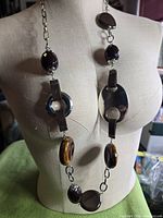 Full view of necklace on dress form highlighting mixed elements and length