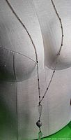 Necklace displayed on dress form, full length view showing chain and pendant
