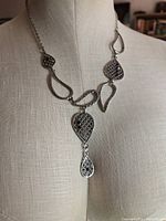 Full view of necklace on bust form showing design and drop