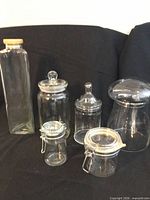 All six clear glass jars grouped together showing shapes and lids