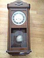 Front view of closed clock showing dial and lower glass