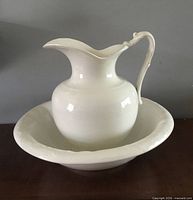 White porcelain pitcher placed inside matching bowl, frontal view