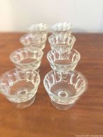 Eight clear footed dessert cups in two rows