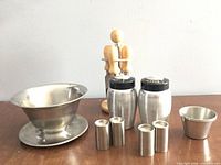 Full lot showing gravy boat, cheese knife set on holder, large shakers, miniature shakers and ramekins
