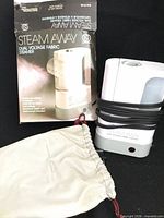 Steamer, pouch and original box grouped together